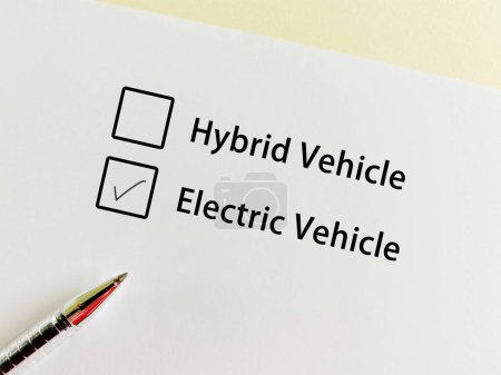 Téléchargez les photos : Une personne répond à la question sur les véhicules. Il choisit un véhicule électrique plutôt qu'un véhicule hybride. - en image libre de droit