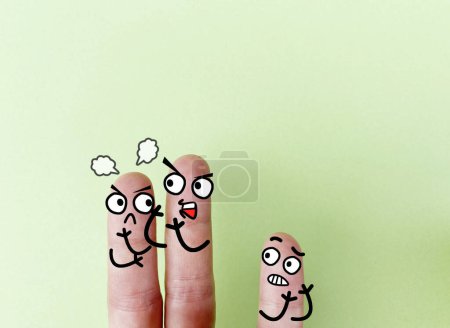 Photo for Three fingers are decorated as parents and a young child. The young child is sad and worried about his parents' marriage. - Royalty Free Image