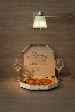 Téléchargez les photos : Une proposition romantique d'amour avec de délicieuses pizzas et l'inscription sur la boîte de Merry Me. Photo de haute qualité - en image libre de droit