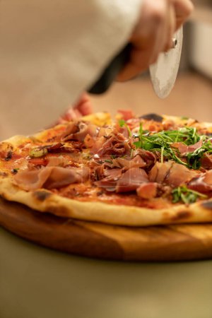 Téléchargez les photos : Juicy, fragrant delicious pizza on the table top view on a sunny day. High quality photo - en image libre de droit