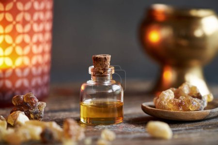 Téléchargez les photos : Une bouteille d'huile essentielle d'encens à la résine boswellia, avec une lampe à arôme - en image libre de droit