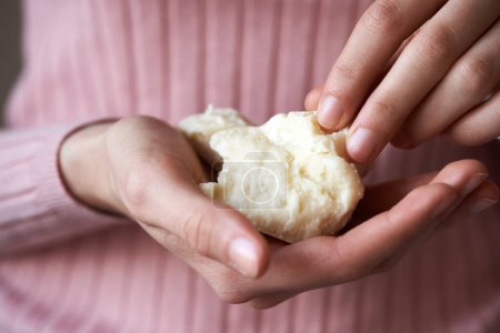 Photo for Raw unrefined shea butter or karite in the hands of a young woman - Royalty Free Image