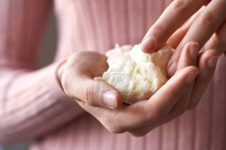 Photo for Woman holding raw unrefined shea butter or karite in her hands - Royalty Free Image