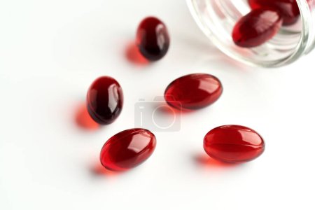 Red krill oil pills on white background. Healthy nutritional supplement.