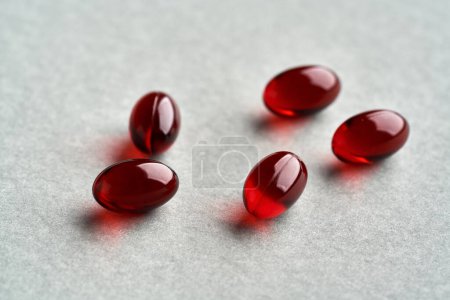 Photo for Red krill oil pills or globules on gray background - Royalty Free Image
