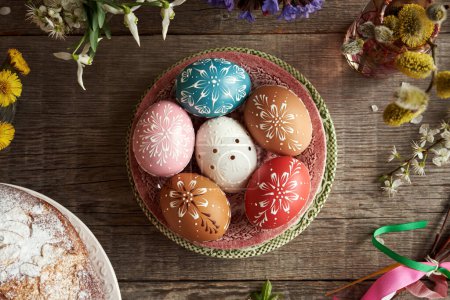 Foto de Coloridos huevos de Pascua decorados con cera con flores de primavera y mazanec - tradicional pastelería dulce checa similar al pan cruzado caliente - Imagen libre de derechos