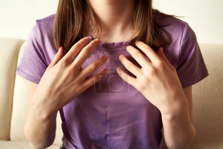 Teenage girl practicing EFT or emotional freedom technique - tapping on the collarbone point