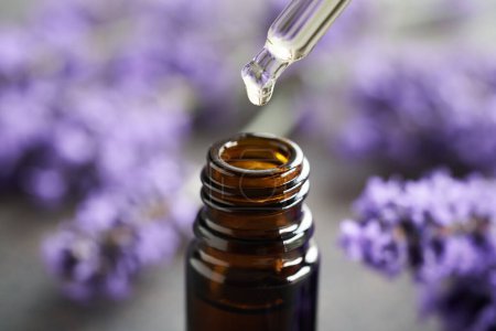 Foto de Aceite esencial de aromaterapia con flores frescas de lavanda y un gotero - Imagen libre de derechos