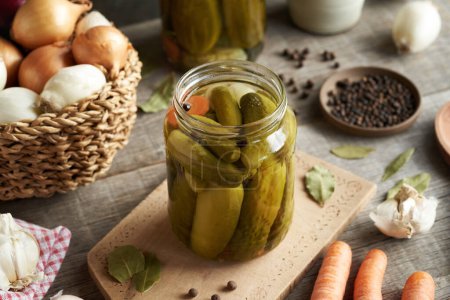 Homemade cucumber pickles or gherkins in a glass jar on a table