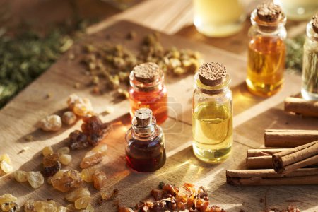 Foto de Frascos de aceites esenciales de aromaterapia con incienso, mirra, canela y hierbas secas - Imagen libre de derechos