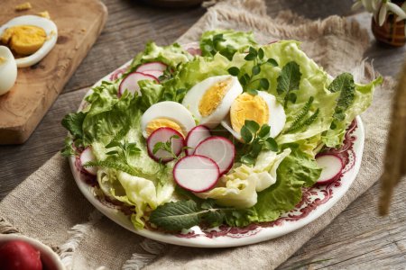 Un plato de ensalada de primavera con huevos y plantas comestibles silvestres - pollito, pezón y milenrama