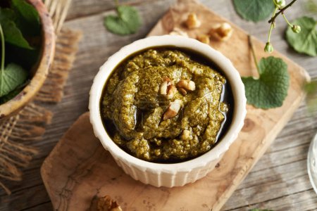 Green pesto sauce made of fresh young garlic mustard leaves - wild edible plant harvested in early spring