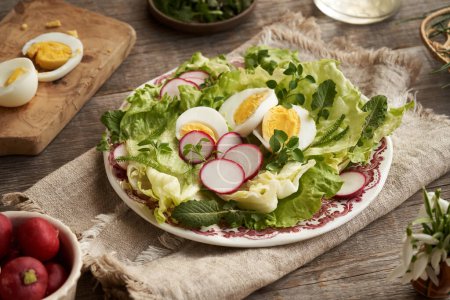 Salade de printemps avec ?ufs et plantes sauvages comestibles - potamot, tétranyque et achillée sur une table