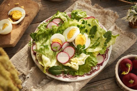 Un plato de ensalada de verduras de primavera con huevos y plantas comestibles silvestres - pollito, pezón y milenrama