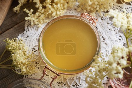 Photo for A jar of homemade elderberry flower syrup prepared in spring, top view - Royalty Free Image