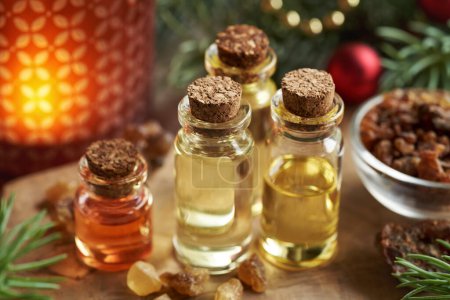 Christmas essential oils with frankincense, myrrh, spruce tree branches and candle