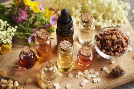 Auswahl an verschiedenen ätherischen Ölen der Aromatherapie mit Myrrhe, Weihrauch und Frühlingsblumen