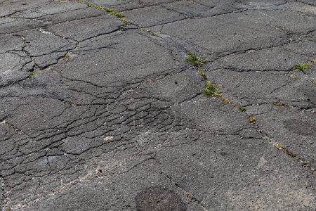 Photo for Extremely decayed street asphalt surface with cracking and crumbling, creative copy space, horizontal aspect - Royalty Free Image
