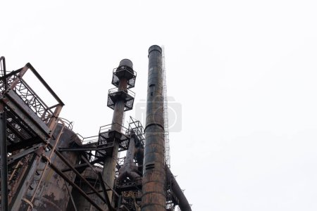 Photo for Large smokestacks with caged ladders and open platforms, Rust Belt architecture, horizontal aspect - Royalty Free Image