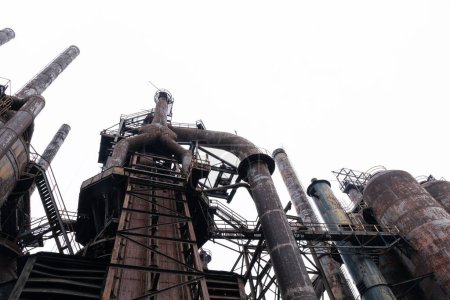 Foto de Vista hacia arriba de oxidantes estructuras abandonadas de la fábrica de acero contra un cielo gris en invierno, aspecto horizontal - Imagen libre de derechos