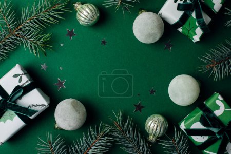 Téléchargez les photos : Composition à plat avec sapin, coffrets cadeaux et décor de Noël sur fond vert. Joyeux Noël carte de vœux, cadre. Thème vacances de Noël d'hiver. Bonne année. Pose plate - en image libre de droit