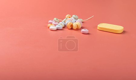 Téléchargez les photos : Tablet Candies Bracelet, Compressed Sugar Powder Confectionery, Dextrose Candy Necklace Parts, Lozenges on Pink Background - en image libre de droit
