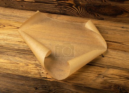Téléchargez les photos : Papier de cuisson brun, Feuille de papier de cuisson Kraft sur fond de texture en bois, Maquette de parchemin de boulangerie, Papier de cuisson résistant aux graisses - en image libre de droit