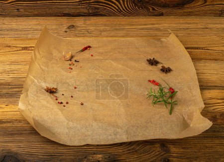 Téléchargez les photos : Papier de cuisson brun avec des herbes et des épices, Feuille de papier de cuisson Kraft sur fond de texture en bois, Mockup de parchemin de boulangerie, Papier de cuisson résistant aux graisses - en image libre de droit