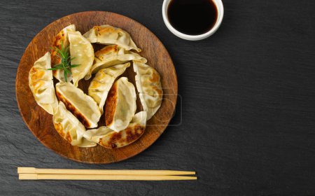 Photo for Gyoza Chinese Dumplings on Wood Plate, Fried Vegetable Jiaozi, Chicken Momo Pile, Asian Gyoza Group, Stone Background, Top View, Copy Space - Royalty Free Image
