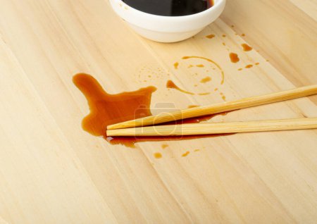 Foto de Sausa de soja derramada sobre mesa de madera, Gotas de Teriyaki, Salsa de ostra en tazón blanco, Puddles de vinagre balsámico sobre fondo de tabla de madera Vista superior - Imagen libre de derechos