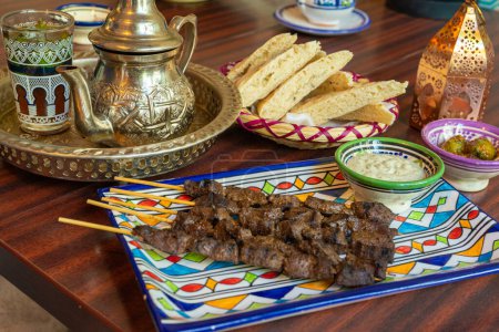 Photo for Moroccan Beef Kebab on Skewers, Traditional Arabian Food, Mutton Shashlik, Skewered Grilled Veal Meat, Spicy Lamb Grill with White Sauce - Royalty Free Image