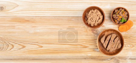 Photo for Pet Food on Wooden Floor Background, Wet Food for Cats in Wood Bowl with Carrots, Dog Canned Pate, Soft Pet Food on White Background - Royalty Free Image