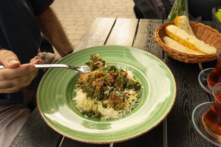 Pilau auf grünem Teller, Beef Pilaf, traditionelles aserbaidschanisches Gericht Plov auch bekannt als Polow, Pilav, Pallao, Pulao, asiatisches Palaw mit Reis, Gewürzen, Gemüse und gebratenem Kalb