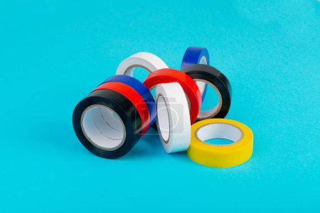 Foto de Colorful Electrical Tape, Plastic Duct Tape Rolls, Colored Adhesive Tapes on Blue Background - Imagen libre de derechos