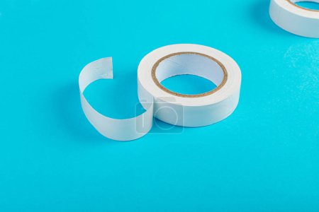 Foto de White Electrical Tape, Plastic Duct Tape Rolls, Colored Adhesive Tapes on Blue Background - Imagen libre de derechos