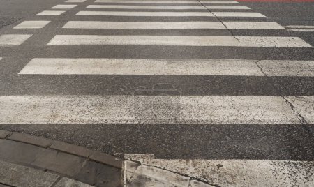 Foto de Cruce peatonal de invierno, paso peatonal blanco negro después de la lluvia, sucia, cebra de seguridad húmeda en el camino de las baldosas modernas - Imagen libre de derechos