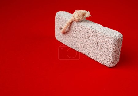 Photo for Pumice Stone on Red Bacground, Grey Porous Lava Piece, Volcano Stone for Foot Care, Basalt Extrusive Igneous Rock, Foot Wellness Pumice Stone on Color Backdrop, Spa Concept - Royalty Free Image
