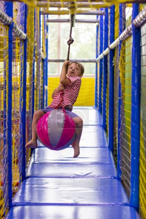 Photo for Boy riding a hanging ball. entertainment center - Royalty Free Image