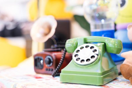 Foto de Teléfono giratorio verde antiguo en mesa de madera para la decoración casera clásica. decoración de la cafetería. - Imagen libre de derechos