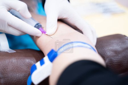 Photo for The doctor is taking a blood sample from the patient's arm for examination. - Royalty Free Image