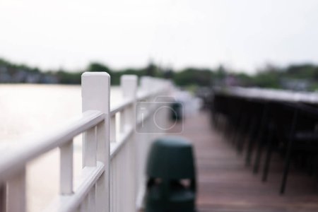 Balcon en bois blanc balustrade d'un restaurant au bord de la rivière fond flou clair.