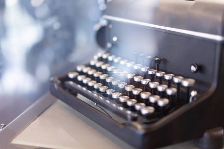 Vista lateral de una máquina de escribir vintage Máquina de escribir antigua sobre fondo de luz bokeh.