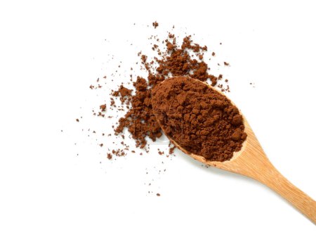 Pile of cocoa powder in wooden spoon isolated on white background. Top view.