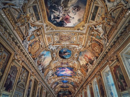 Photo for The Galerie d'Apollon a large and iconic room of the Louvre museum. Apollon gallery is a gold decorated hall with zodiac signs ornaments and murals on the walls and ceiling. Architectural masterpiece - Royalty Free Image