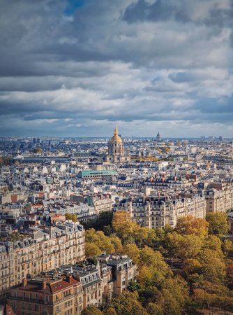 Photo for Scenery aerial view from the Eiffel tower height over the Paris city, France. Les Invalides building with golden dome seen on the horizon. Autumn parisian cityscape - Royalty Free Image