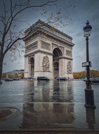 Téléchargez les photos : Arc de Triomphe (Arc de triomphe) à Paris, France. Jour d'automne pluvieux avec une vue romantique sur le point de repère historique de la rue, fond vertical - en image libre de droit
