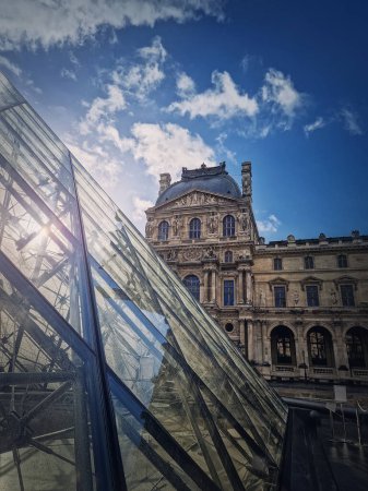 Photo for Outdoors view to the Louvre Museum in Paris, France. Vertical shot of the historical palace building with the modern glass pyramid in front - Royalty Free Image
