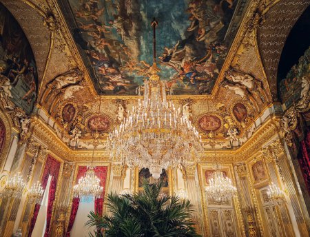 Photo for Beautiful decorated Napoleon apartments at Louvre palace. Royal family rooms with cardinal red curtains, golden ornate walls, paintings and crystal chandeliers suspended from ceiling - Royalty Free Image