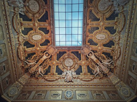 Foto de Techo dorado con detalles arquitectónicos del Salón Carre dentro del Museo del Louvre, París, Francia. Adornos dorados con esculturas dedicadas a Murillo y Poussin - Imagen libre de derechos