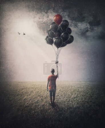 Téléchargez les photos : Bizarre scene of a lone person in the field holding a bunch of balloons in his hand in hope of starting flying. Conceptual and inspirational art - en image libre de droit